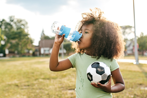 Kid drinking water at playground by Highridge Dental Care.